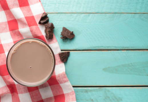 Glass of chocolate milk on vintage wood background,top view