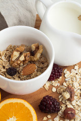 cereal, milk jug with milk, berries and nuts