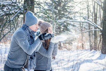 Young couple in love blows snow