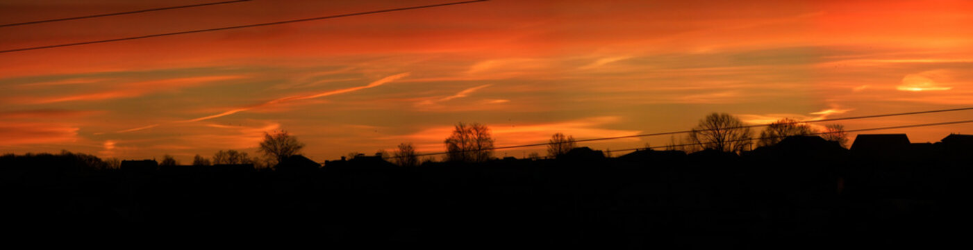 Panorama of sunrise and silhouettes of houses