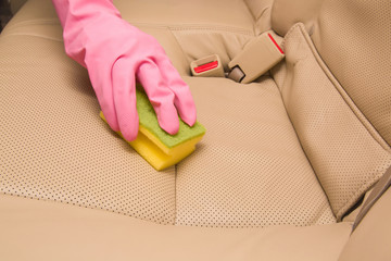 Car interior leather seats professionally chemical cleaning with sponge. Early spring cleaning or regular clean up.