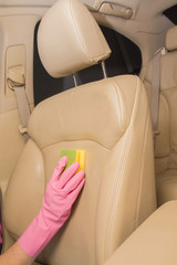 Fototapeta premium Car interior leather seats professionally chemical cleaning with sponge. Early spring cleaning or regular clean up.