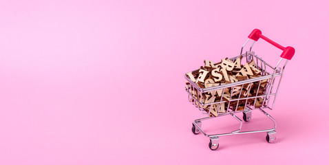 Shopping basket with letters of the alphabet made of wood on a pink background