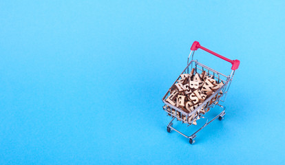 Shopping basket with letters of the alphabet made of wood on a blue background