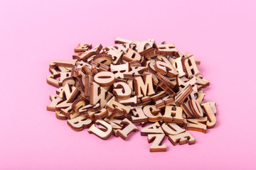 Wooden letters of the English alphabet on a pink background
