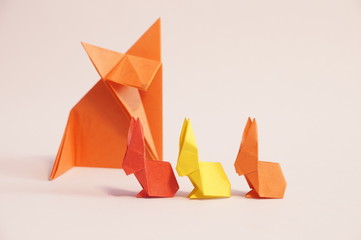 Fototapeta na wymiar Paper origami rabbit and fox are isolated on a colorful background