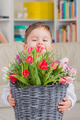 kleiner junge mit frühlingsblumen