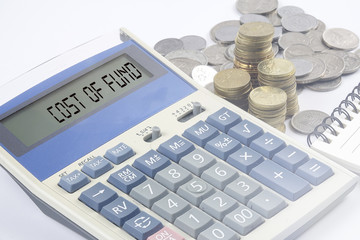 Coins and calculator with business and finance conceptual text.