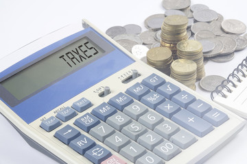 Coins and calculator with business and finance conceptual text.