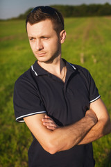serious man standing in field on the grass