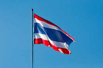 blurred of Thai or siam flag with pole on blue sky background