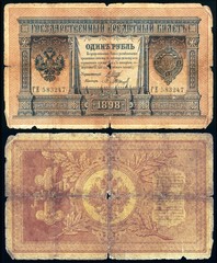 Fototapeta na wymiar Old dilapidated Russian banknote of 1 ruble in 1898. Isolated on a black background. The front and back side.