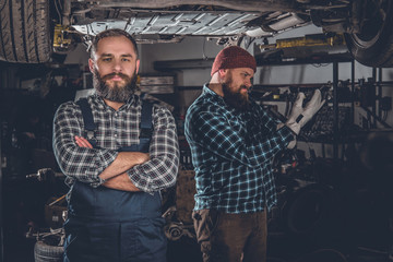 Fototapeta na wymiar Two bearded mechanics in a garage.