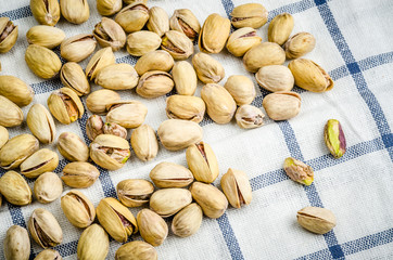 roasted and salted pistachios on table cloth.