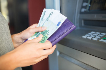 close up of hand withdrawing money at atm machine