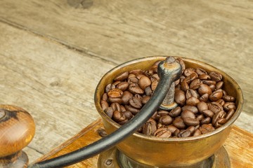 Old wooden coffee grinder on a wooden table. Homework hot coffee. Advertising for the sale of coffee.