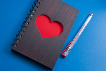A notebook with a large red heart on a blue background,