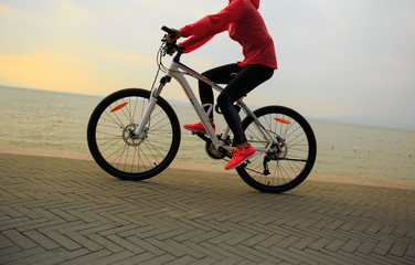Fototapeta na wymiar healthy lifestyle young woman riding bike on seaside