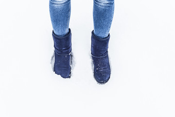 female legs in the snow in blue UGG
