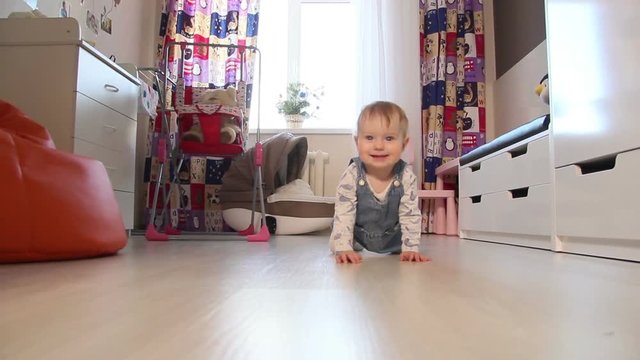 Happy little baby crawling in the living room of the house White baby smiling .Children in the house.
