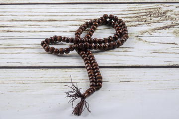 the wooden tasbih or rosary on wooden background.