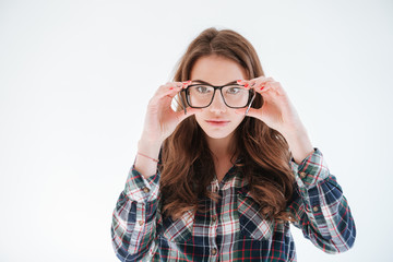 Woman standing and holding glasses in fromt of her eyes