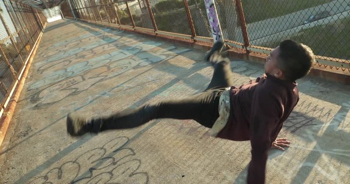 Young man breakdancing on a bridge