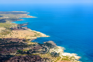 View from above to the Cyprus island sea coast with blue water and lagoons. Akamas cape landscape. Natural seasonal summer vacation background.