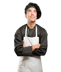 Happy young chef looking up