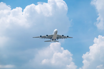 Fototapeta na wymiar Airplane on bright blue sky background with white clouds