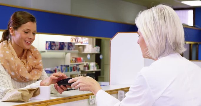 Customer entering pin code on payment terminal in pharmacy