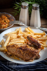 Roasted chicken with french fries on a plate.