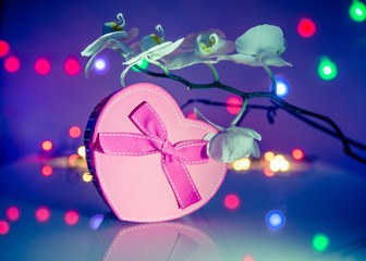gift box in form of heart on the background of the white orchid 