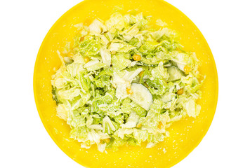 Vegetable salad of cabbage, corn and cucumber in the white plate isolated