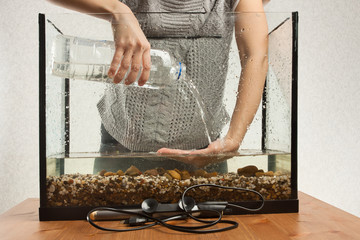 aquarist pouring water in aquarium