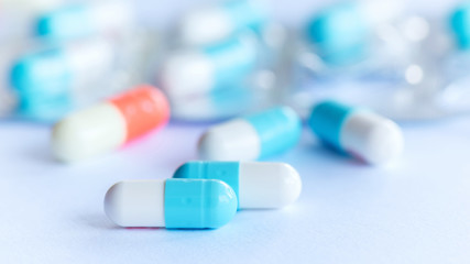 Closeup pills capsule with many capsule blur on white