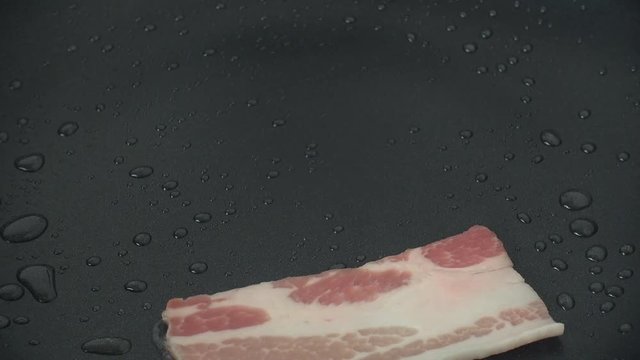 Woman frying slices of bacon on pan for pasta, 4k video