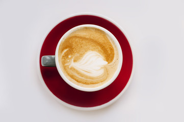 fresh morning cappuccino in a red cup on a white background