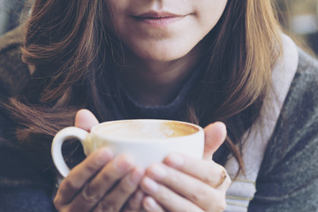 Closeup image of Asian woman drinking hot coffee with feeling sad