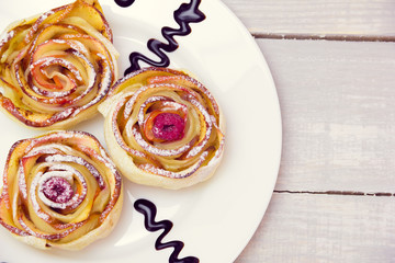 three apple muffins on a plate on a wooden grey background 