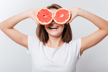 Cheerful young lady holding grapefruit