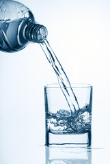 Water pouring from bottle into glass