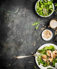 Healthy green diet salad with chicken , Pine nuts and olive oil dressing  on dark rustic...