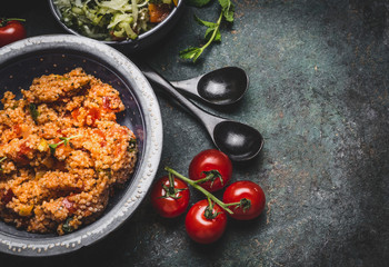 Healthy vegetarian couscous salad in bowl on rustic background, top view, close up, border.  Diet eating, Vegetarian or vegan food concept