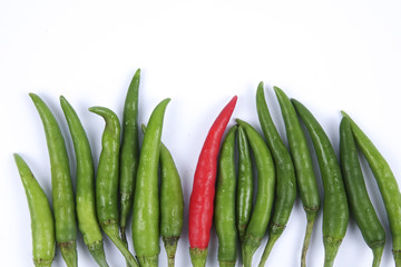 Red chili on green chillies on white background concept : different, win, better