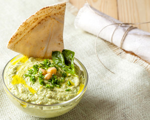 Bowl of green hummus,delicious cream of chickpeas and basil