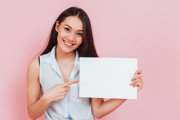 Young attractive woman holding blank billboard with copy space
