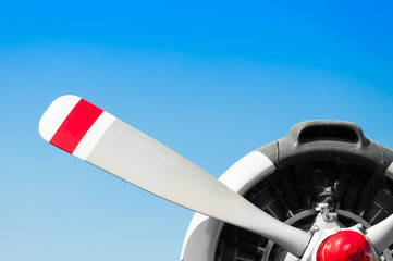 Vintage airplane propeller with radial engine on blue sky