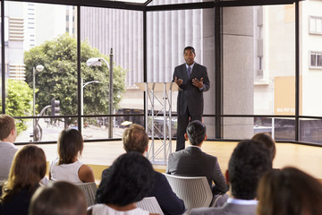 Black businessman presenting seminar gesturing to audience