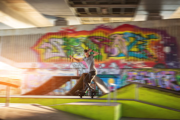 Young man on rollerblades. Rollerblader in skatepark. Skills of extreme sportsman.